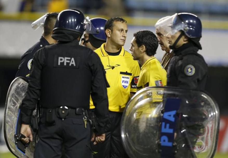 I poliziotti in assetto anti sommossa circondano l&#39;arbitro Dario Herrera, che decider di sospendere il match dopo un&#39;ora di colloquio con giocatori e dirigenti di entrambe le squadre. Reuters